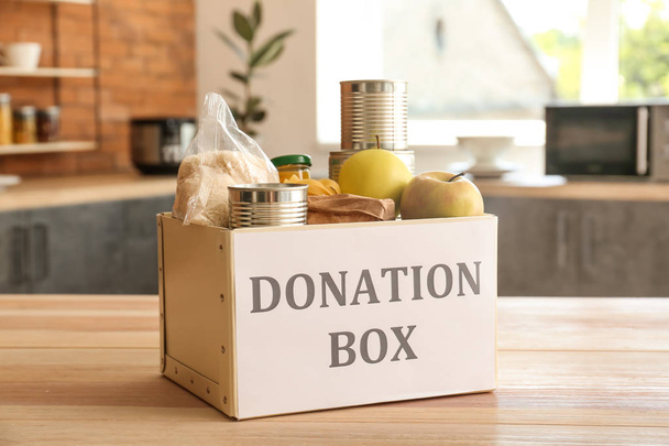 Коробка з їжею пожертвування на столі на кухні
 - Фото, зображення