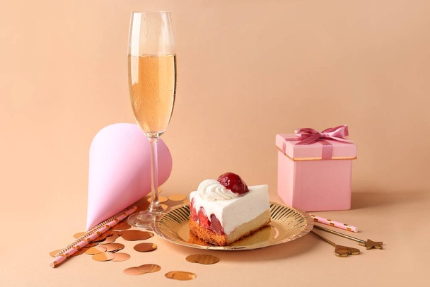 Plate with Birthday cake, gift box and glass of champagne on color background - Photo, Image