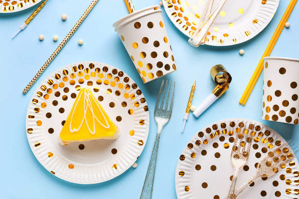 Tarta de cumpleaños con platos y tazas sobre fondo de color
 - Foto, imagen