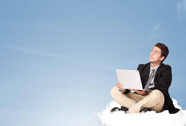 Attractive businessman sitting on cloud with copy space - Photo, Image