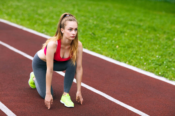 Beautiful athlete on a race track is ready to run. - 写真・画像
