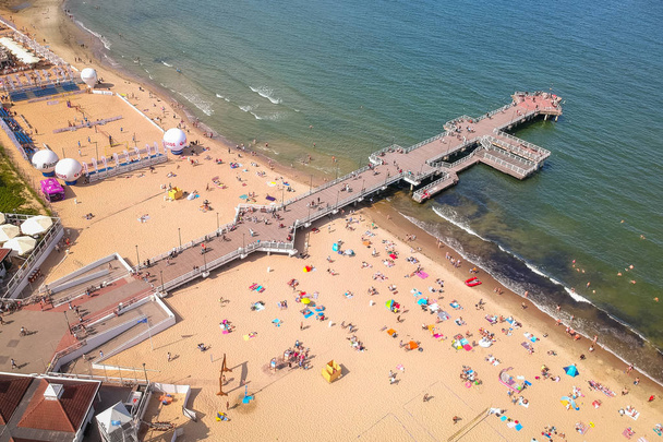 Gdansk, Poland - August 3, 2019: People relaxing on the beach with wooden pier at Baltic Sea in Gdansk, Poland. - Foto, Imagen
