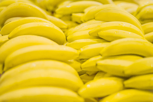 Куча желтых бананов в супермаркете. Свежий и здоровый. Небольшая глубина резкости, сосредоточьтесь на передней части банана
. - Фото, изображение