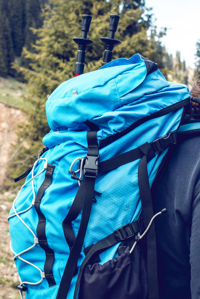 Ember túrázás hegyekben nagy piros utazási hátizsák. Utazó férfi a zöld kalap trekking útja során. Utazás, emberek, sport és egészséges életmód koncepció - Fotó, kép