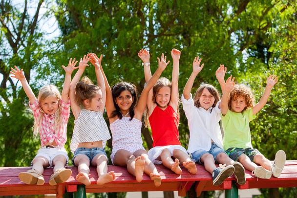 Happy kids raising hands outdoors. - Photo, Image
