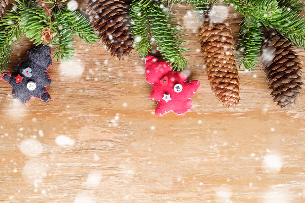 Cornice natalizia con rami di abete, pigne, decorazioni tessili ed effetto neve
 - Foto, immagini