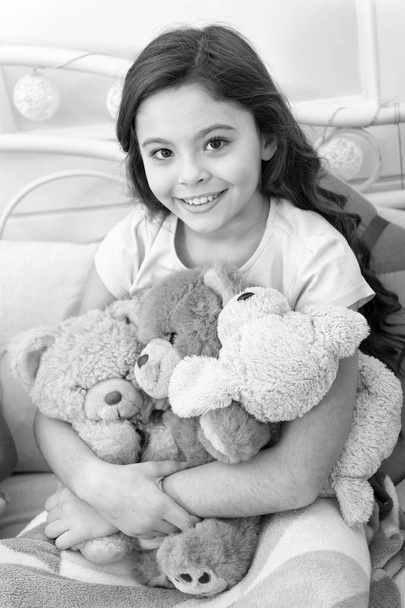 Favorite toys. Christmas gift concept. Teddy bear improve psychological wellbeing. Child small girl playful hold teddy bear plush toy. Kid little girl play toy teddy bear interior background - Zdjęcie, obraz