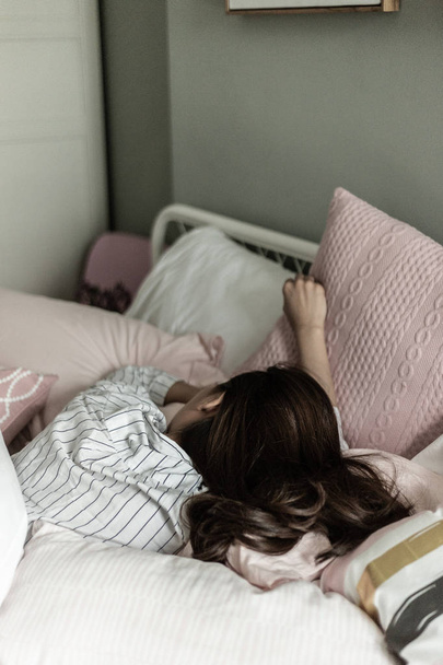 πίσω όψη του κοριτσιού που κοιμάται στο κρεβάτι στο σπίτι - Φωτογραφία, εικόνα