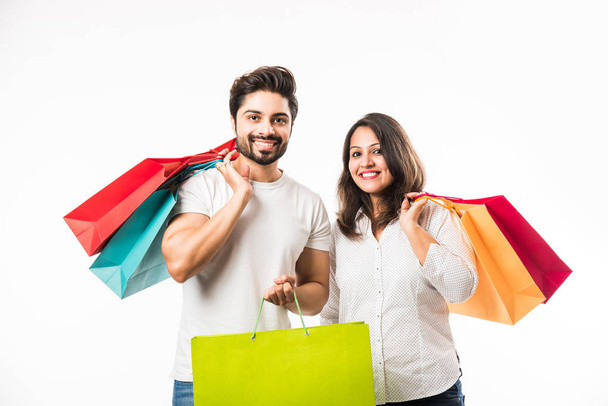 Indian young couple shopping bags, standing isolated over white background. selective focus - Photo, Image