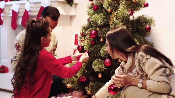 Fröhliche Familie schmückt Weihnachtsbaum  - Filmmaterial, Video