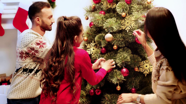 Glückliche Familie schmückt Weihnachtsbaum  - Filmmaterial, Video
