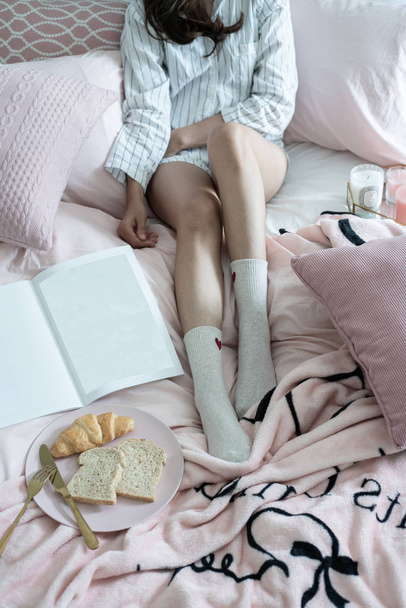 cropped shot of girl sitting on bed and having breakfast  - Фото, зображення