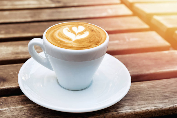 Verse cappuchino of platte witte koffie in een witte beker met Latte Art erop - Foto, afbeelding