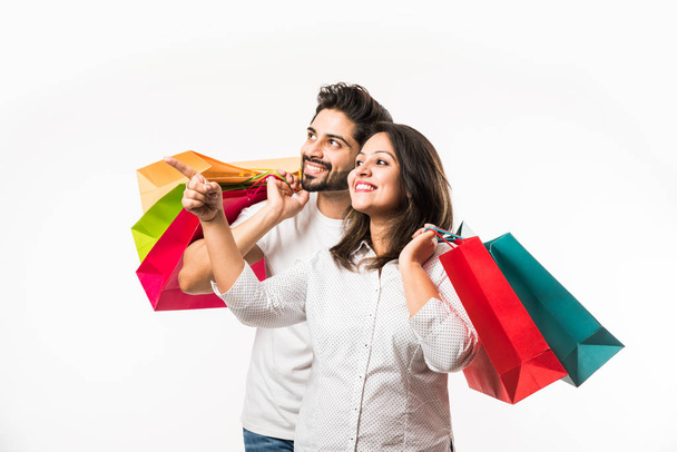 Indiano giovane coppia borse della spesa, in piedi isolato su sfondo bianco. focus selettivo
 - Foto, immagini