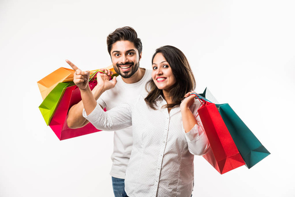 Indian young couple shopping bags, standing isolated over white background. selective focus - Photo, image
