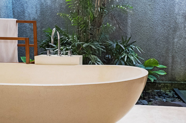 Stone bathtub in modern villa with open space bathroom. - Photo, image