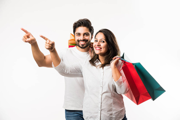 Indian young couple shopping bags, standing isolated over white background. selective focus - Zdjęcie, obraz