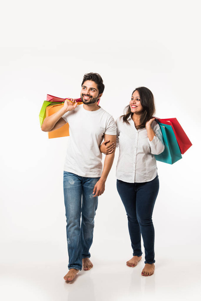 India joven pareja bolsas de compras, de pie aislado sobre fondo blanco. enfoque selectivo
 - Foto, Imagen
