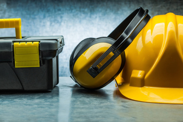 tool box earphones and yellow construction helmet on metalic bac - Foto, Bild