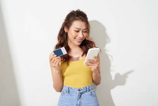Asian young woman holding a card and mobile phone - Photo, Image