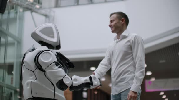 Kölcsönhatás az ember és a modern technológiák a mesterséges intelligencia. Közelről férfi keze tudós rázza robotkaros. Robotika és az emberi kezek csatlakoznak a kézfogás. Találkozó-és üdvözlés barátok - Felvétel, videó