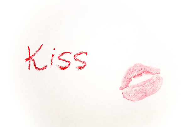 Red lipstick, word in English made with lipstick. Lips mark on a white surface. Isolated on white               - Photo, image