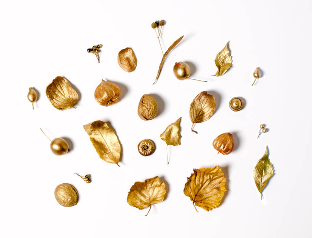 Bright golden autumn leaves, wild apples, and physalis flowers on a white background. Beautiful autumn frame. Top view photo. - Фото, изображение