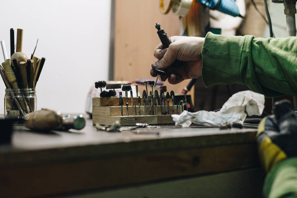 Jeweler choosing nozzles for engraver - Фото, изображение