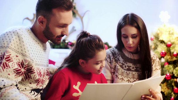 glückliche Familie liest Buch über Weihnachten  - Filmmaterial, Video