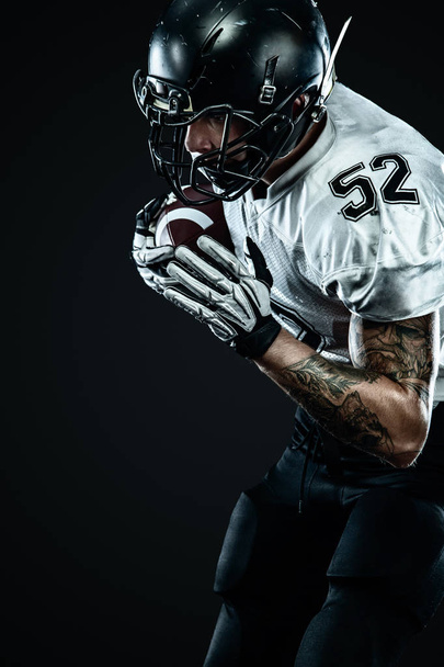 American football sportsman player in helmet isolated on black background. Sport and motivation wallpaper. - Фото, изображение