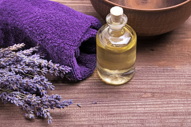 Massage oil bottle and lavender flowers on wooden background - Fotografie, Obrázek