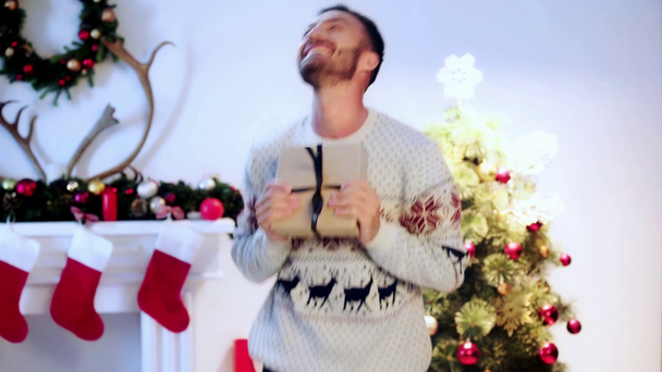  hombre barbudo feliz sosteniendo regalo en Navidad
  - Metraje, vídeo