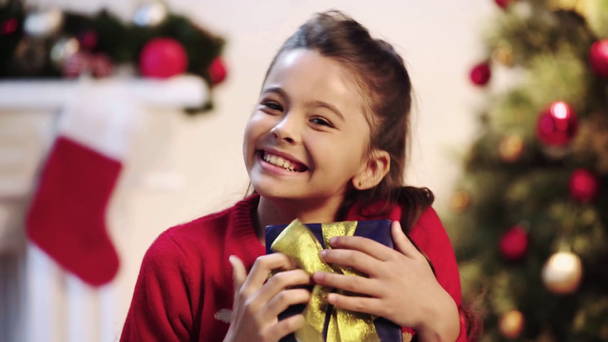 glückliches Kind küsst Geschenk zu Weihnachten  - Filmmaterial, Video