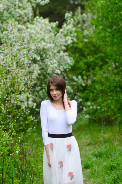 hermosa chica en un parque floreciente
 - Foto, imagen