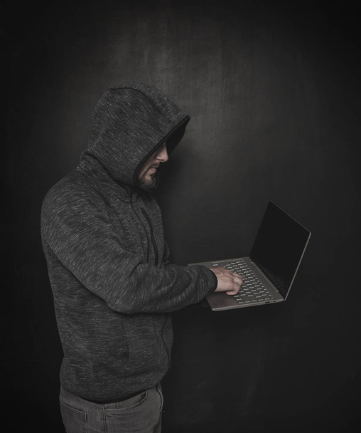 Homme programmeur pirate utilisant un ordinateur portable sur sombre
 - Photo, image