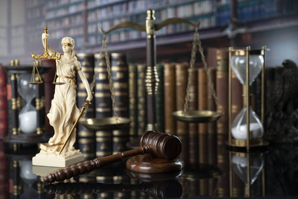 Το σκεπτικό του νόμου. Λευκό άγαλμα της Θέμης, νομικά βιβλία και κλίμακα στο τραπέζι στην παλαιά δικαστική βιβλιοθήκη. - Φωτογραφία, εικόνα