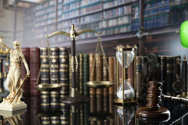 De concept achtergrond van de wet. Wit standbeeld van Themis, juridische boeken en schaal op de tafel in de oude gerechts bibliotheek. - Foto, afbeelding