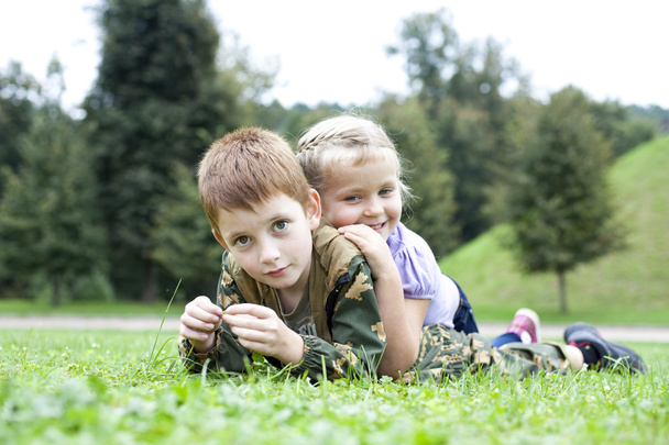 Children lying on the green grass in the park - Valokuva, kuva