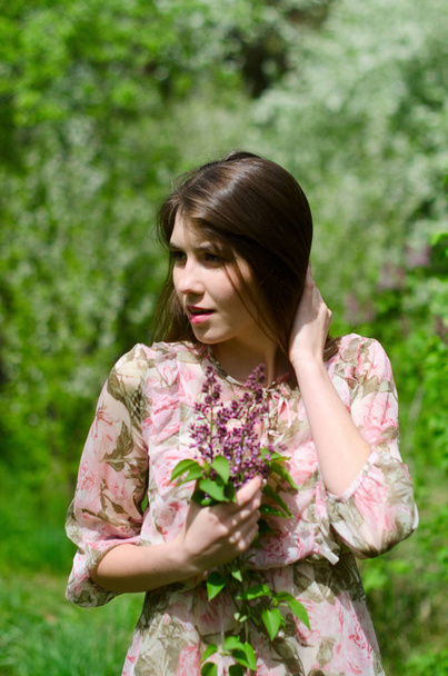 kaunis tyttö kukkivassa puistossa
 - Valokuva, kuva