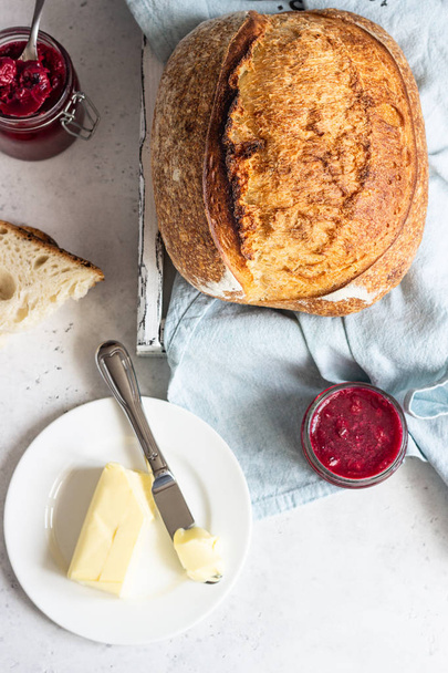 Toasted white artisan bread with butter and jam on light grey stone table. Simple breakfast. - 写真・画像