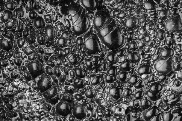 Nahaufnahme der Oberfläche von Obsidian oder schwarzem Vulkanglas - Foto, Bild