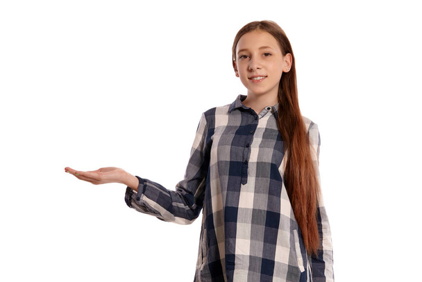 Bella ragazza adolescente in una camicia a scacchi casuale è in posa isolato su sfondo bianco studio
. - Foto, immagini