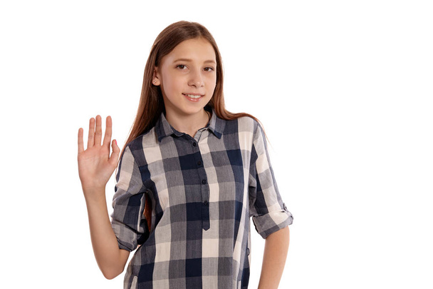 Beautiful teenage girl in a casual checkered shirt is posing isolated on white studio background. - Foto, Imagen
