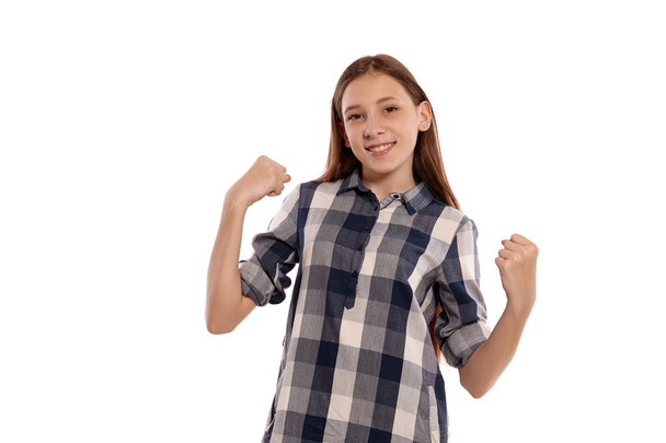 Красивая девочка-подросток в обычной клетчатой рубашке позирует изолированно на белом фоне студии
. - Фото, изображение