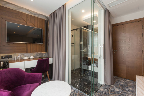 Interior of a luxury hotel apartment room with glass wall bathro - Photo, Image