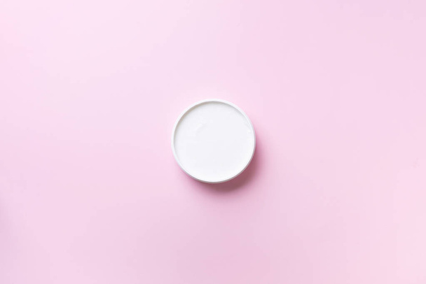 Body butter jar on pink background with copy space. Skin care product, natural cosmetic, cream concept. Top view, flat lay - 写真・画像