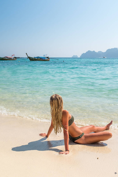 woman sunbathing sitting down on the tropical beach - Φωτογραφία, εικόνα