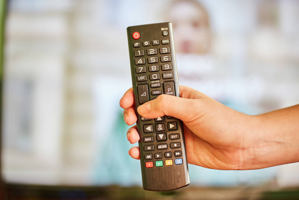 young girl watching tv and holding a remote control from tv - Photo, Image
