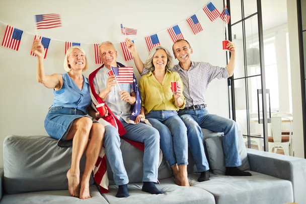 Täyspitkä muotokuva ryhmä eläkeläisiä heiluttaen Yhdysvaltain lippuja jännityksessä, kopioi tilaa
 - Valokuva, kuva