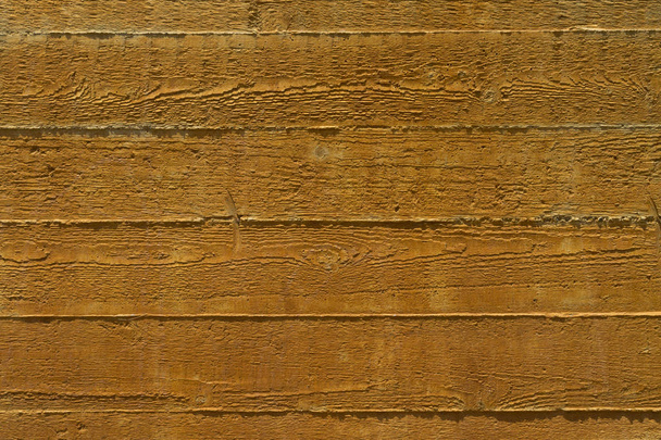 Osa aidan vaakasuorasta karkea keltainen puinen lankkuja auringonvalossa
 - Valokuva, kuva